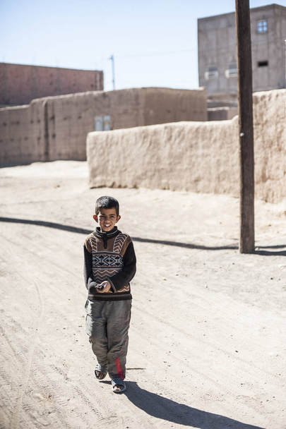 Portret van een jongen kijken op de camera in dorp Merzouga, Marokko - Foto, afbeelding