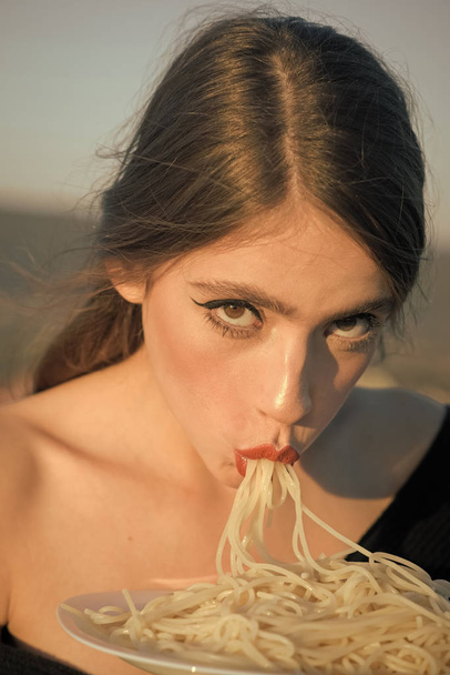 Beautiful young brunette woman eating Italian meal. - Fotó, kép