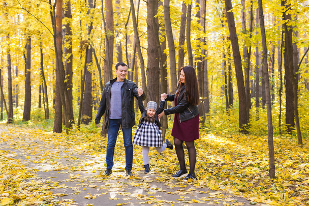 Elternschaft, Herbst und Menschen-Konzept - junge Familie glücklich im Herbstpark - Foto, Bild