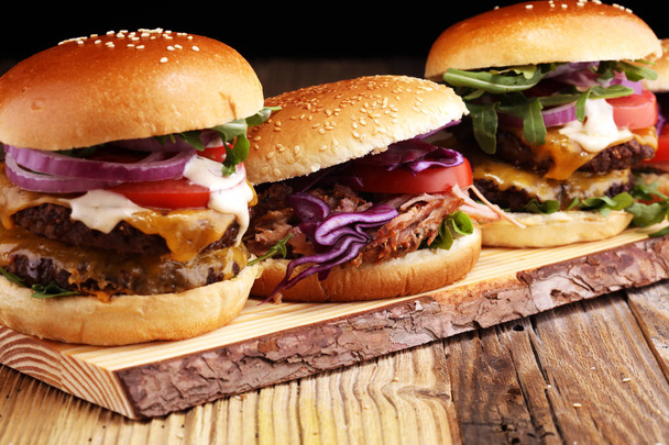 Lekker vers vlees hamburgers met salade en kaas. Zelfgemaakte angus hamburger en broodjes van Pulled pork - Foto, afbeelding