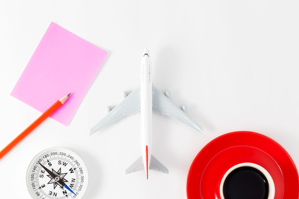 Airplane model with pencil and paper note,compass and red coffee cup  on white background - Photo, Image