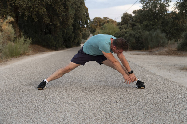 Atleta sano fare stretching esercizio rilassante e riscaldarsi dopo il jogging e la corsa
 - Foto, immagini