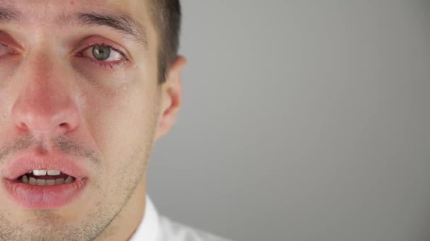 Half face portrait of depressed man crying with tears in eye. Man in despair. - Video, Çekim