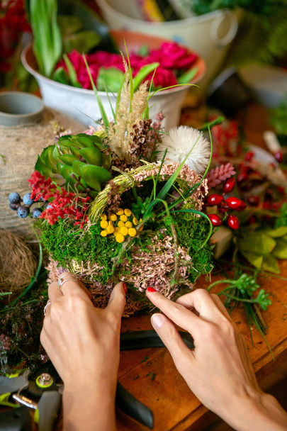 Female hands making beautiful bouquet and composition of flowers on background - Foto, immagini