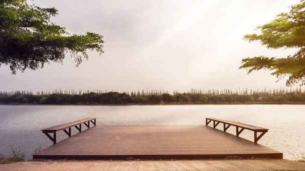 朝の夜明けに湖に注ぐ川と木の桟橋。 - 写真・画像