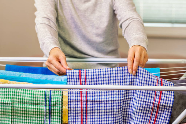 Ama de casa recoge toallas de la secadora
 - Foto, Imagen