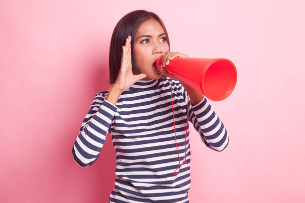 Beautiful young Asian woman announce with megaphone on pink background - Foto, imagen