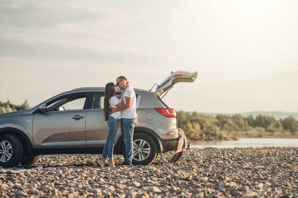 Счастливая пара по дороге на закат в автомобиле SUV
 - Фото, изображение