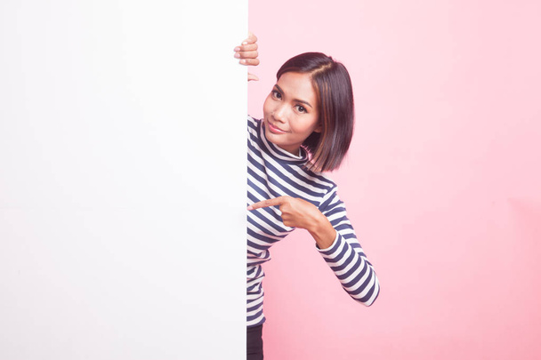 Young Asian woman point to a  blank sign on pink background - Фото, зображення