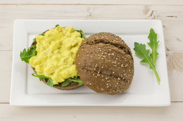 Dark bread with curried chicken salad on a white plate - Photo, Image