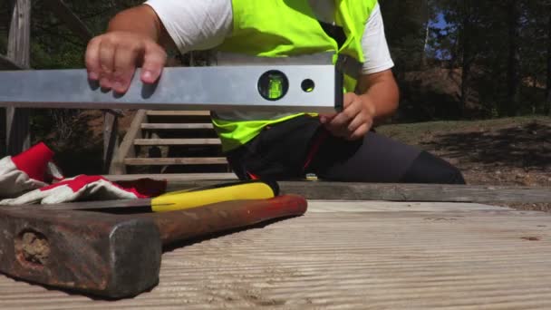 Travailleur sur escalier en bois avec niveau
 - Séquence, vidéo