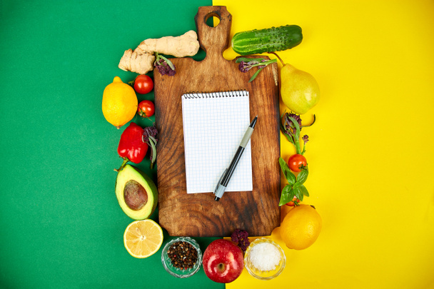 Λίστα αγορών, βιβλίο συνταγών, σχέδιο διατροφής. Φρέσκα ωμά λαχανικά, φρούτα και υλικά για υγιεινό μαγείρεμα. κάτοψη, η θέση για το κείμενο. Τροφίμων διατροφή ή vegan, χορτοφάγος και υγιεινά μαγειρική έννοια. Επίπεδη θέσει. Σημειωματάριο (Notepad) για την ιδέα σας συνταγή.  - Φωτογραφία, εικόνα