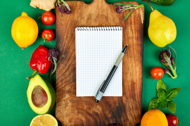 Shopping list, recipe book, diet plan. Fresh raw vegetables, fruit and  ingredients for healthy cooking. top view, place for text. Diet or vegan food, vegetarian and healthily cooking concept. Flat lay. Notepad for your recipe concept.  - Photo, image