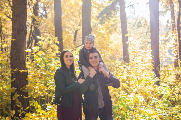 Children, nature and family concept - Portrait of happy family over autumn park background - Photo, image