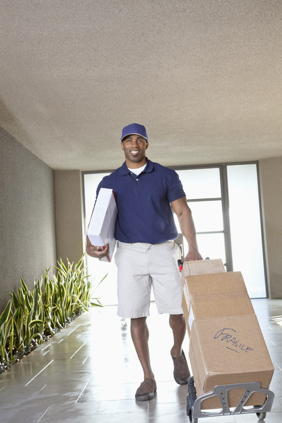 Happy African American delivery man with packages - Foto, afbeelding