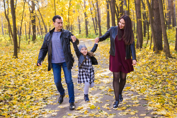 Lidé, rodina a volný čas koncepce - matka, otec a malá dcerka bavit na podzim park - Fotografie, Obrázek