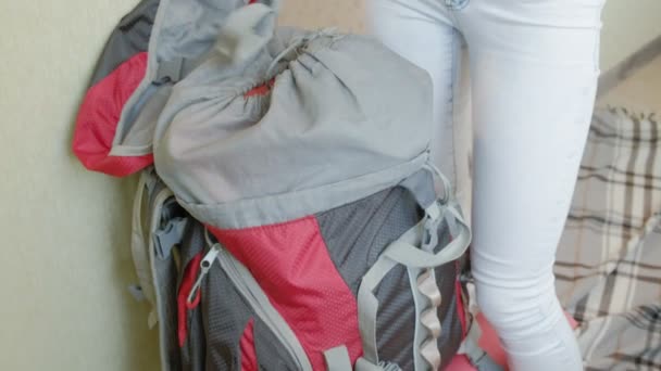 A woman tourist collects things in a backpack in the kitchen of the house and prepares for a trip - Metraje, vídeo