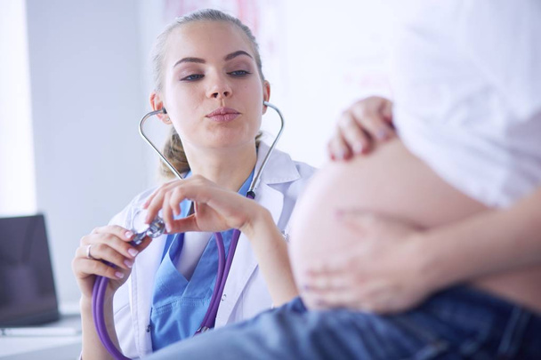 Young female doctor examining pregnant woman at the clinic. - Foto, immagini