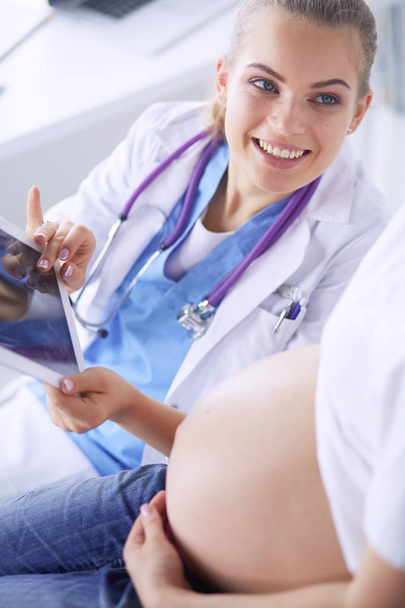 Jeune femme médecin examinant une femme enceinte à la clinique. - Photo, image