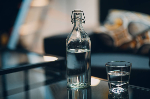 Flesje en glas met schoon water - Foto, afbeelding