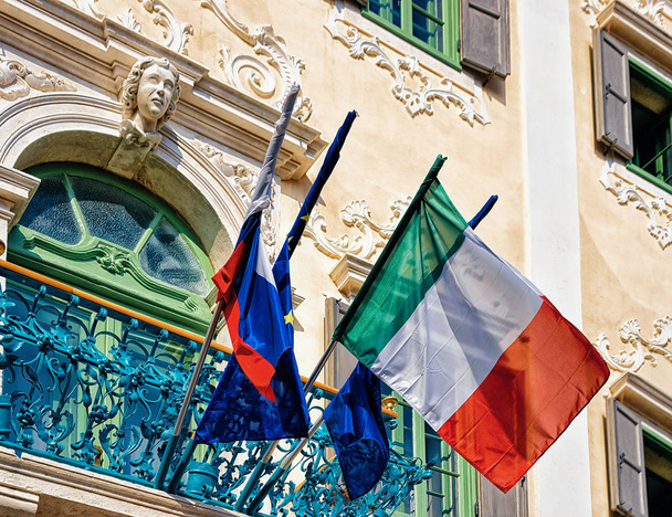 Bandeiras no edifício no centro histórico da cidade velha de Izola, Eslovênia
 - Foto, Imagem