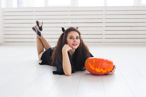 Halloween et concept de mascarade - Belle jeune femme posant avec citrouille Jack-o-lanterne
. - Photo, image