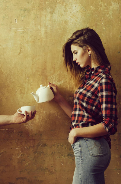 Pretty girl pouring tea to cup in male hand - Photo, image