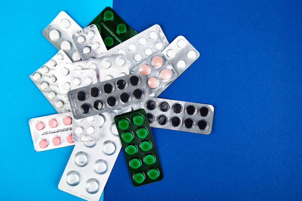 Pillen, Tabletten und Blister auf blauem Hintergrund. Gesundheitskonzept. flach lag. Kopierraum. - Foto, Bild