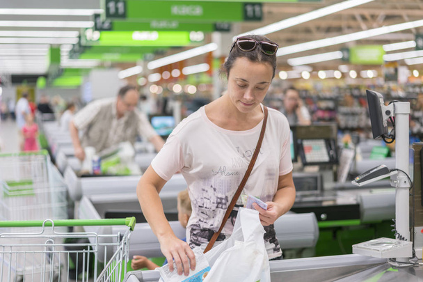Женщина средних лет на кассе в супермаркете. Женщина рассчитывает на мошенников в супермаркете
. - Фото, изображение