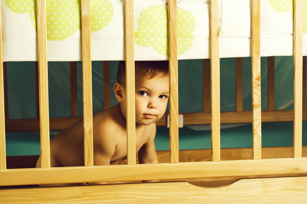 little boy hid behind cot - Φωτογραφία, εικόνα