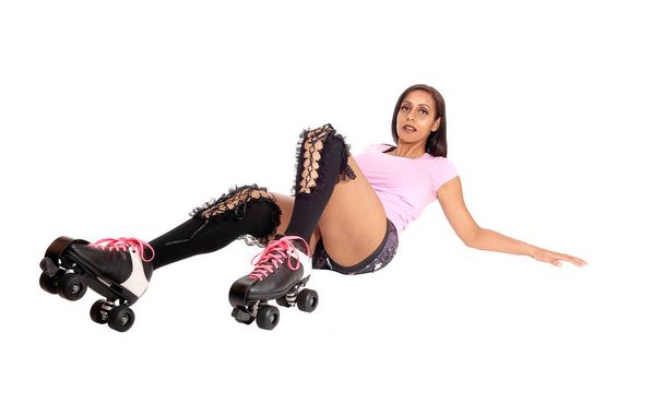 A pretty woman with roller skates and shorts lying on the floo - Φωτογραφία, εικόνα