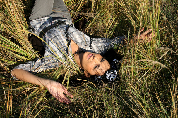 Beautiful young woman lying on field - Fotoğraf, Görsel