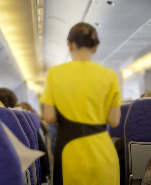 Blurred abstract Flight attendant serving passengers on the plane. The concept of care by the people. - Photo, Image