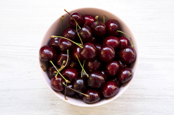 Full pink bowl of cherries, top view. Flat lay, overhead, from above. Close-up. - Photo, Image