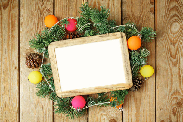 Christmas holiday background with photo frame, decorations and ornaments on wooden table. Top view from above.  - Photo, image