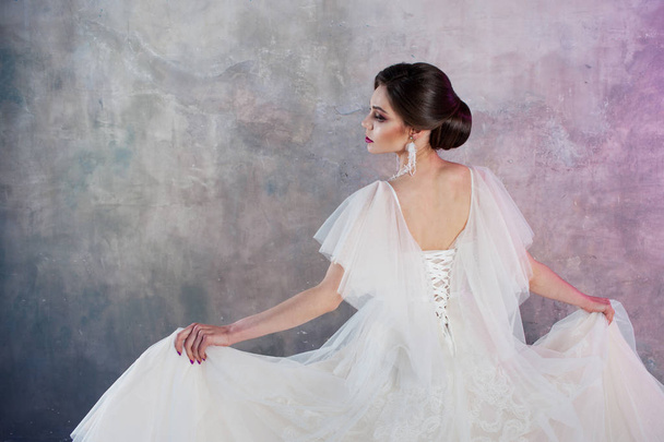 back view of a young elegant brunette bride with a stylish hairstyle. - 写真・画像