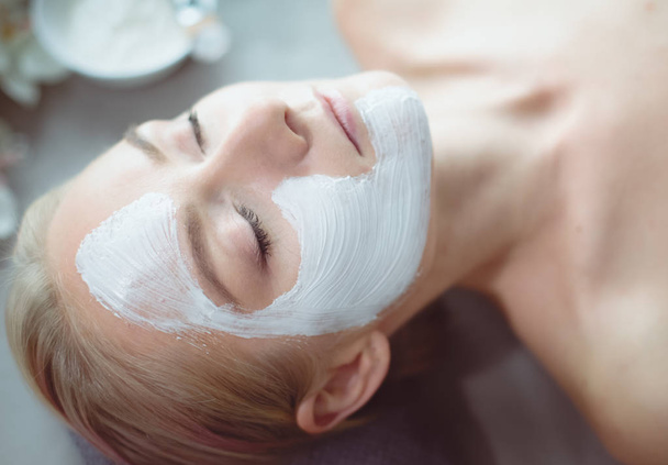 Face mask.Beautiful young girl at spa ,cosmetician woman applying facial mask. - Foto, immagini