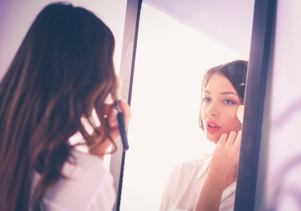 Jovem mulher olhando-se reflexo no espelho em casa. Jovem mulher
. - Foto, Imagem