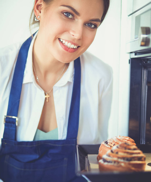 Woman cook holding plate with homemade baked goods - Photo, image
