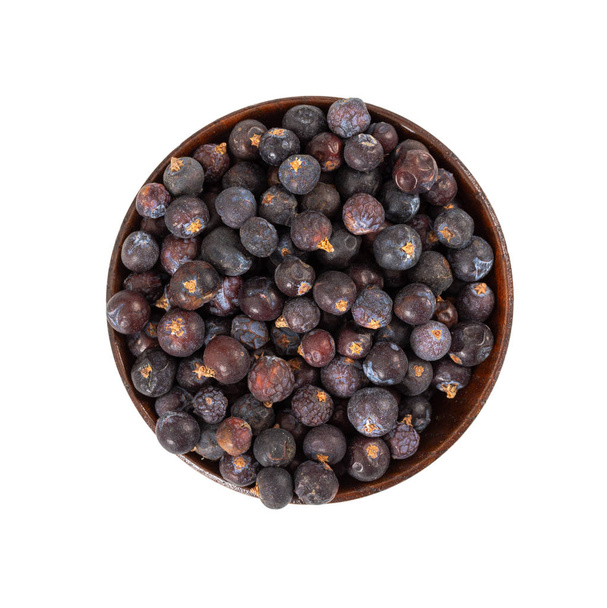 Dried juniper berries in wooden bowl isolated on white background. Top view. - Photo, Image
