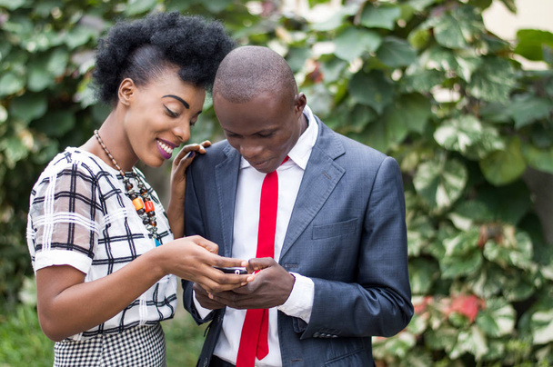 Молодые люди счастливы, чтобы проконсультироваться вместе мобильный телефон на открытом воздухе
. - Фото, изображение