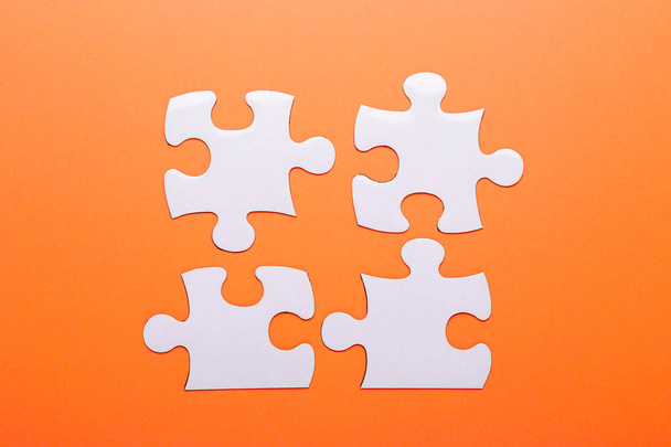 White puzzle on orange background. Missing piece. Top view - Фото, изображение