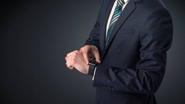 Man in suit wearing smartwatch. - Valokuva, kuva