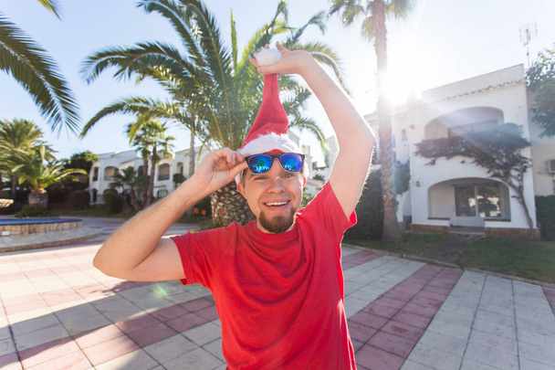 Vánoce, svátky, humor, lidé koncept - muž vzlet vánoční klobouk z hlavy - Fotografie, Obrázek