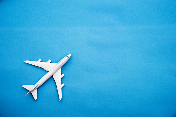 Plat leggen van miniatuur speelgoed vliegtuig op blauwe achtergrond minimaal reis en reizen van creatieve concepten. Ruimte voor de kopie. - Foto, afbeelding
