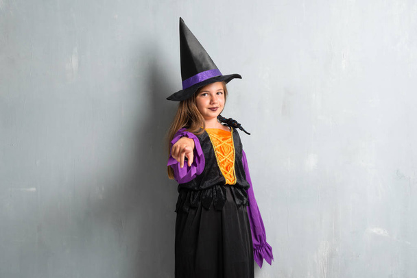 Pieni tyttö pukeutunut noita halloween loma osoittaa edessä
 - Valokuva, kuva