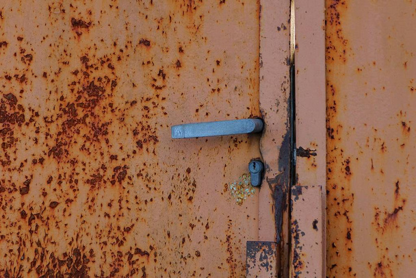 gray doorknob on an old brown rusty wall - Foto, Bild