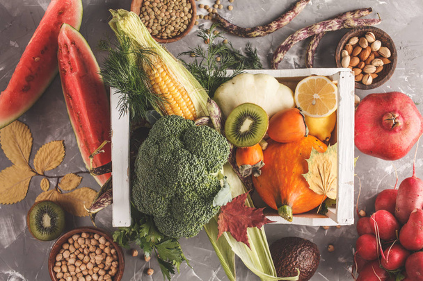 Autumn harvest food in a wooden box. Fruits, vegetables and cereals, healthy food background. Vegan healthy food concept. - Foto, imagen