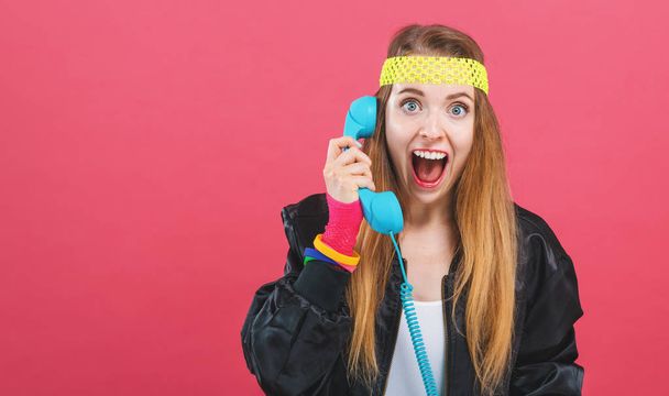 Woman in 1980s fashion with old fashioned phone - Foto, Bild