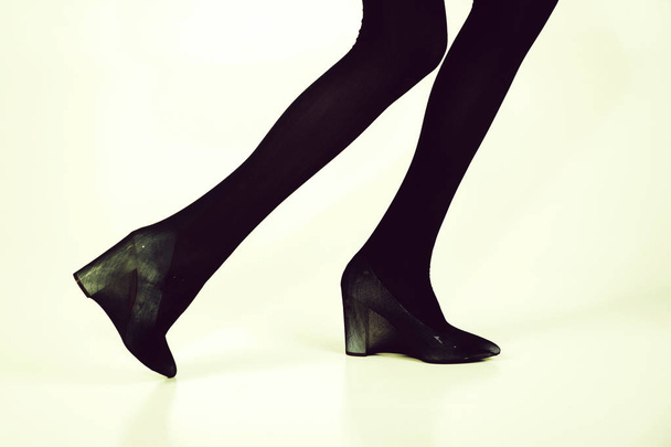 shoes and black tights on slim legs of girl - Fotó, kép